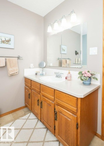 Bathroom vanity featuring a light-toned countertop with integrated sink and chrome faucet - 10711 108 Avenue, Westlock, AB - Indoor Photo Showing Bathroom