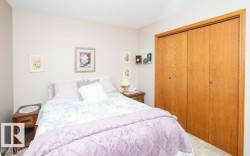 Bedroom featuring light-colored walls, textured ceiling, and wood bi-fold closet doors - 