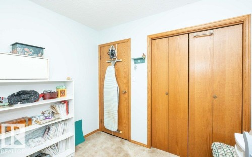 White shelving unit with multiple storage tiers, light wood-finish doors, and matching trim - 10711 108 Avenue, Westlock, AB - Indoor Photo Showing Other Room