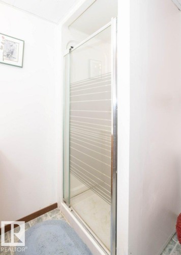 Shower enclosure with sliding glass doors, a frosted privacy stripe, and a chrome frame - 10711 108 Avenue, Westlock, AB - Indoor