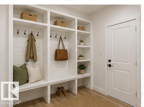 Built-in white storage cabinetry featuring open shelving, coat hooks, and bench seating - 3320 Chickadee Drive Nw, Edmonton, AB - Indoor