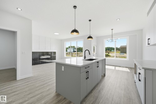 Contemporary kitchen island featuring a deep undermount sink, quartz countertop, and matte black faucet - 3 Pierwyck Loop, Spruce Grove, AB - Indoor Photo Showing Kitchen With Upgraded Kitchen