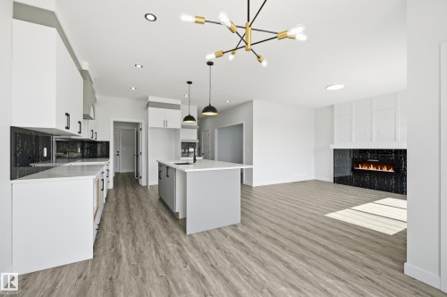 Open-concept living space with wood-finish flooring - 3 Pierwyck Loop, Spruce Grove, AB - Indoor Photo Showing Kitchen With Fireplace