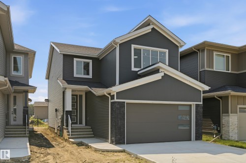 Two-story residence featuring a dark gray facade with horizontal siding and a stone accent column - 3 Pierwyck Loop, Spruce Grove, AB - Outdoor With Facade