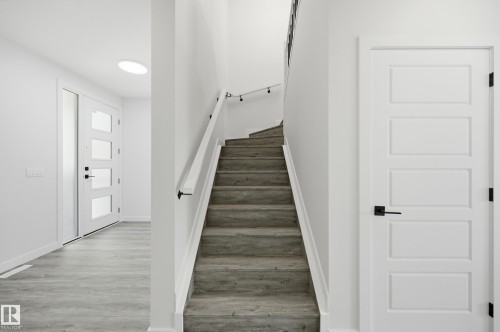 Staircase featuring wood-finish treads and a white handrail with black supports - 3 Pierwyck Loop, Spruce Grove, AB - Indoor Photo Showing Other Room