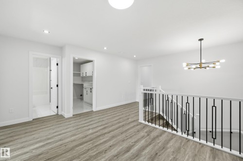 Upper-level landing featuring wood-finish flooring, recessed lighting, and a modern chandelier - 3 Pierwyck Loop, Spruce Grove, AB - Indoor Photo Showing Other Room