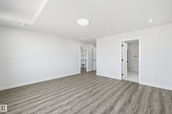 Spacious room featuring wood-finish flooring and a neutral color palette - 