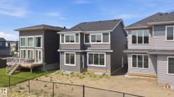 Contemporary residential architecture featuring multi-story design with prominent windows and dark grey siding - 