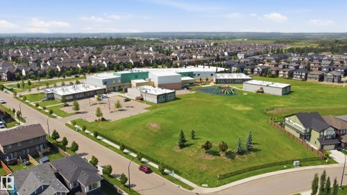 Aerial perspective showcasing a contemporary educational facility with extensive green spaces and a playground structure - 3 Pierwyck Loop, Spruce Grove, AB - Outdoor With View