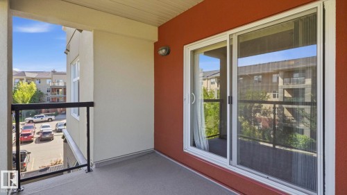 Private balcony featuring a concrete surface, black metal railing, and direct access through a white-framed sliding glass door - #361 7805 71 St Nw, Edmonton, AB - Outdoor With Balcony With Exterior