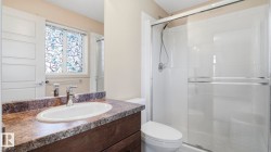 Bathroom vanity featuring a vessel sink, chrome faucet, and a patterned countertop - 