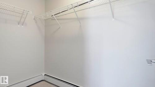Walk-in closet featuring wire shelving, light gray walls, and carpet flooring - #361 7805 71 St Nw, Edmonton, AB - Indoor With Storage