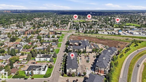 Aerial perspective showcasing multi-story residential buildings with dark shingled roofs and brick accents, surrounded by paved parking areas - #361 7805 71 St Nw, Edmonton, AB - Outdoor With View