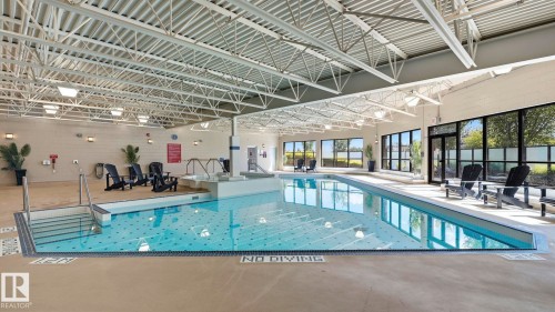 Indoor aquatic facility featuring an in-ground swimming pool with an integrated spa - #361 7805 71 St Nw, Edmonton, AB - Indoor Photo Showing Other Room With In Ground Pool