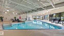 Indoor aquatic facility featuring an in-ground swimming pool with an integrated spa - 