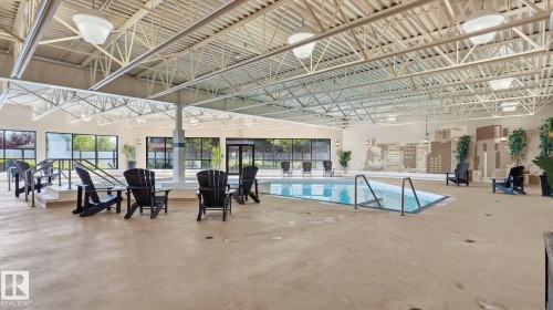 Indoor swimming pool featuring a perimeter overflow design with integrated entry steps and handrails - #361 7805 71 St Nw, Edmonton, AB - Indoor Photo Showing Other Room With In Ground Pool
