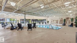 Indoor swimming pool featuring a perimeter overflow design with integrated entry steps and handrails - 