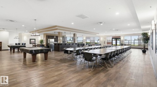 Spacious common area featuring wood-finish flooring and extensive natural light from multiple windows - #361 7805 71 St Nw, Edmonton, AB - Indoor Photo Showing Dining Room