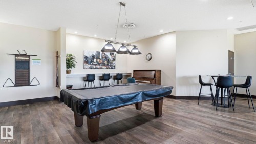 Recreation room featuring wood-finish flooring and a central billiard table - #361 7805 71 St Nw, Edmonton, AB - Indoor
