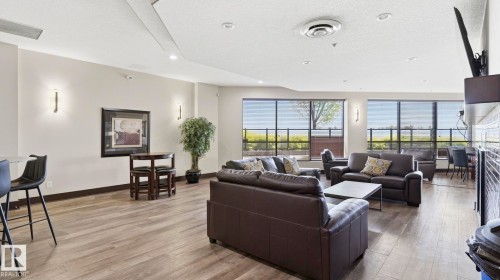 Spacious common area featuring wood-finish flooring, recessed lighting, and large windows with horizontal blinds - #361 7805 71 St Nw, Edmonton, AB - Indoor Photo Showing Living Room