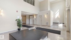 Spacious entry foyer featuring high ceilings, light-toned wall finishes, recessed lighting, and large format tile flooring - 