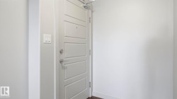 Modern entry door with five horizontal panels, satin nickel hardware, and a door closer mechanism - 