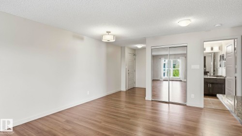 Spacious interior featuring wood-finish flooring, light neutral wall tones, and recessed lighting - #361 7805 71 St Nw, Edmonton, AB - Indoor Photo Showing Other Room