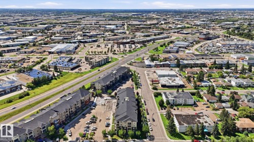 Aerial perspective showcasing a mixed-use district with commercial buildings, residential structures, and established infrastructure - #361 7805 71 St Nw, Edmonton, AB - Outdoor With View