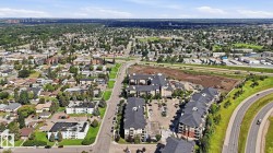 Aerial perspective highlighting a multi-building residential development with dark-toned roofs and multi-level facades - 