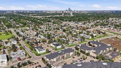 Aerial perspective showcasing a residential neighborhood with green spaces and a distant city skyline - 