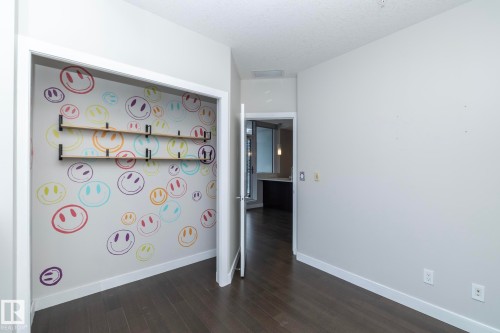 Recessed closet with decorative wall treatment and two built-in wooden shelves - #1201 10238 103 St Nw, Edmonton, AB - Indoor Photo Showing Other Room