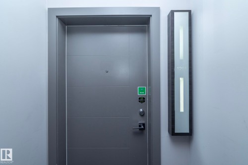 Modern entry door featuring horizontal paneling and a dark gray finish - #1201 10238 103 St Nw, Edmonton, AB - Indoor