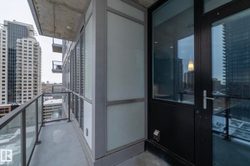 Balcony featuring glass and metal railings, concrete flooring, and an exterior door with glass panels - #1201 10238 103 St Nw, Edmonton, AB - Outdoor With Balcony With Exterior