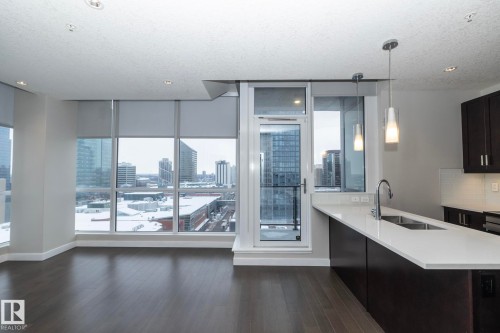 Floor-to-ceiling windows with roller shades, dark wood-finish flooring, and recessed lighting - #1201 10238 103 St Nw, Edmonton, AB - Indoor Photo Showing Kitchen With Double Sink With Upgraded Kitchen