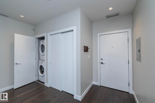 Entryway featuring dark wood-finish flooring, white baseboards, and light gray walls - #1201 10238 103 St Nw, Edmonton, AB - Indoor Photo Showing Laundry Room