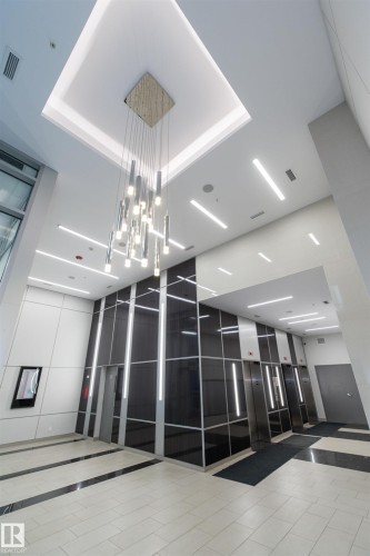 Double-height lobby featuring a tiered chandelier and recessed linear lighting - #1201 10238 103 St Nw, Edmonton, AB - Indoor Photo Showing Other Room