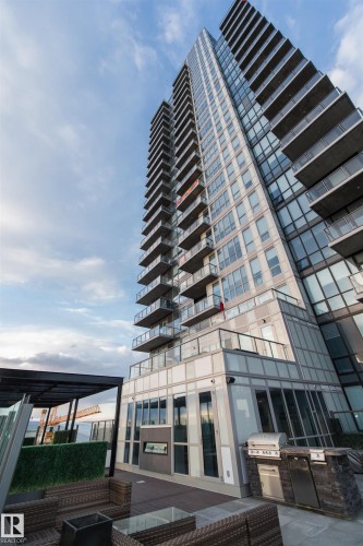 Modern high-rise building featuring extensive glass balconies and a rooftop amenity deck - #1201 10238 103 St Nw, Edmonton, AB - Outdoor With Balcony With Facade