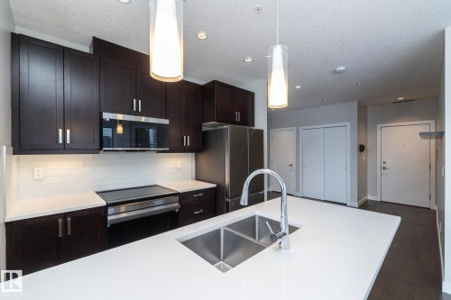 Kitchen featuring a central island with a double stainless steel sink and gooseneck faucet - #1201 10238 103 St Nw, Edmonton, AB - Indoor Photo Showing Kitchen With Double Sink With Upgraded Kitchen