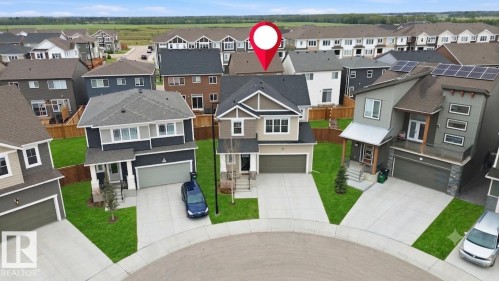 Two-story residence featuring a neutral-toned facade and a dark shingle roof - 1607 202 Street Nw, Edmonton, AB -  With Facade