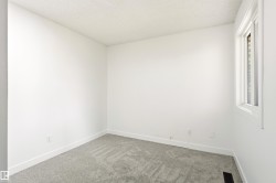Bright interior space featuring a single-pane window, light gray carpet, and white trim - 