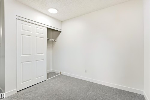 Room featuring light gray carpet, white walls, and a sliding closet door - #4 7604 29 Av Nw, Edmonton, AB - Indoor Photo Showing Other Room
