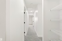 Hallway featuring light gray carpet flooring, white walls, and recessed lighting - 