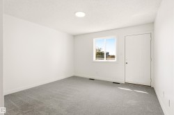 Room featuring light gray carpeting, white painted walls, and a white entry door - 