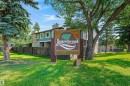 Community entrance sign with established landscaping, featuring mature trees and green lawn space - #4 7604 29 Av Nw, Edmonton, AB  - Outdoor 