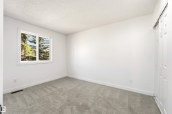 Room with light gray carpet, white walls, and white trim - 