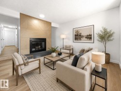 Living area with a contemporary fireplace featuring a wood-panel accent wall and dark stone hearth - 