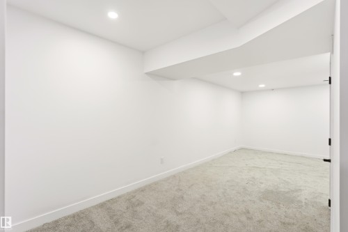 Spacious interior room featuring light gray carpeting, white walls, and recessed lighting - #4 7604 29 Av Nw, Edmonton, AB - Indoor Photo Showing Other Room