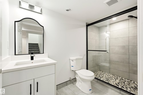Bathroom featuring a white vanity with an integrated sink and quartz countertop - #4 7604 29 Av Nw, Edmonton, AB - Indoor Photo Showing Bathroom