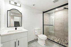 Bathroom featuring a white vanity with an integrated sink and quartz countertop - 