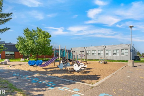 Playground area featuring sand base, purple slide, blue tunnel, and climbing structure - #4 7604 29 Av Nw, Edmonton, AB - Outdoor